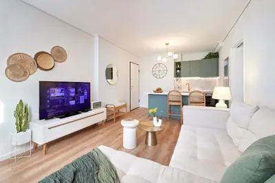 a living room with a couch and a tv at Athens Premium Suites - Sunny 2 Bedroom Suite with Parking in Athens