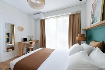 a bedroom with a large bed and a window at Athens Premium Suites - Sunny 2 Bedroom Suite with Parking in Athens
