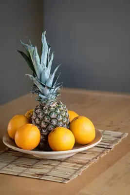 a plate with a pineapple and oranges on a table at 5* Penthouse Acropoli View Loft in Athens