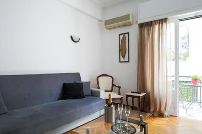 a living room with a blue couch and a table at Athenaeum Acropolis Residence 1min to Museum in Athens
