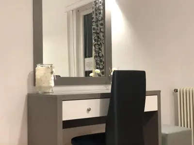 a bathroom with a vanity with a mirror and a chair at Athenaeum Acropolis Residence 1min to Museum in Athens
