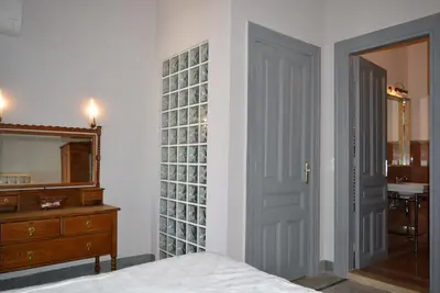 a bedroom with a door and a dresser and a mirror at Athenian Vintage Apartments in Athens