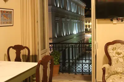 a room with a table and chairs and a balcony at Athenian Vintage Apartments in Athens
