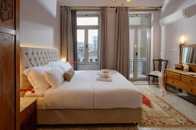 a bedroom with a large white bed and a window at Athenian Vintage Apartments in Athens