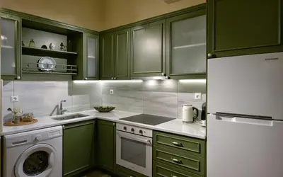 a kitchen with green cabinets and a washer at Athenian Vintage Apartments in Athens