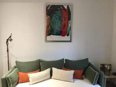 a living room with a couch with a painting on the wall at Elegant Acropolis in Athens