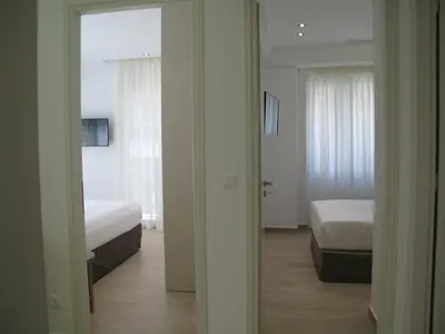 a room with two beds and a bedroom with a mirror at Elegant Acropolis in Athens