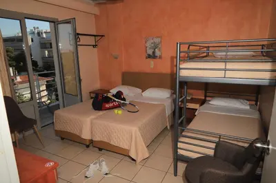 a room with two bunk beds and a chair at IKAROS Hotel ELLINIKO in Athens