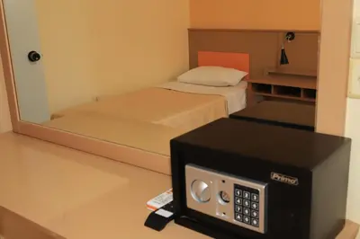 a small room with a bed and a microwave at IKAROS Hotel ELLINIKO in Athens