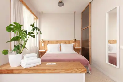 a bedroom with a bed and a potted plant at The Marble Suites, PLAKA in Athens