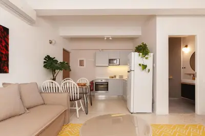 a living room with a couch and a table and a refrigerator at The Marble Suites, PLAKA in Athens