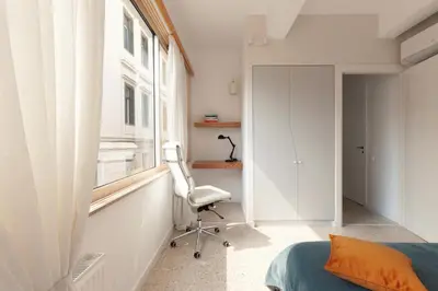 a bedroom with a chair and a window and a bed at The Marble Suites, PLAKA in Athens