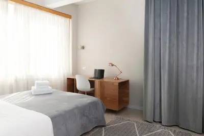 a bedroom with a bed and a desk and a window at The Marble Suites, PLAKA in Athens