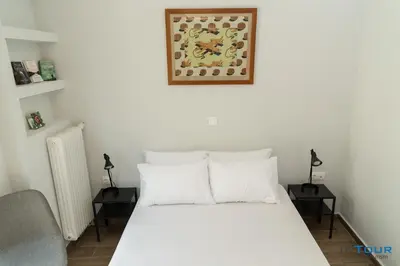 a bedroom with a white bed with two night stands at Art point under Acropolis in Athens