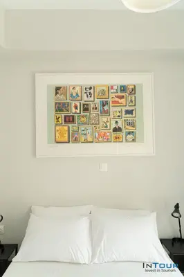 a picture hanging above a bed with a white pillow at Art point under Acropolis in Athens