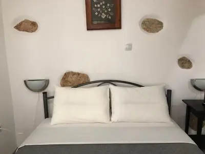 a bedroom with a bed with white pillows on it at Little cottage in Athens