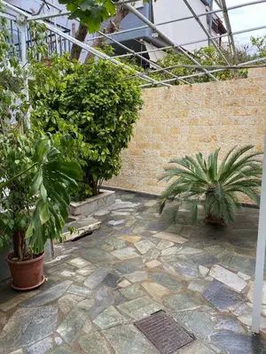 a courtyard with potted plants and a brick wall at Little cottage in Athens