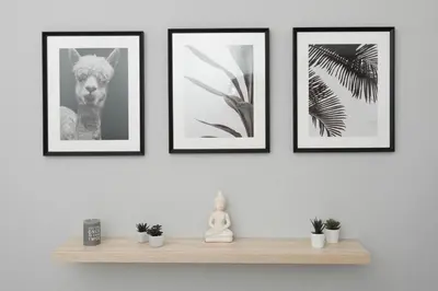 four framed pictures on a wall with a shelf at Spacious apartment-600m from the subway in Athens