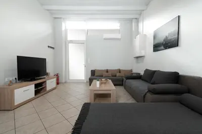 a living room with a couch and a tv at Spacious apartment-600m from the subway in Athens