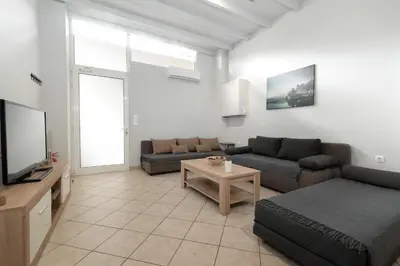 a living room with a couch and a tv at Spacious apartment-600m from the subway in Athens