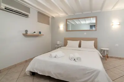 a bedroom with a white bed with two towels on it at Spacious apartment-600m from the subway in Athens