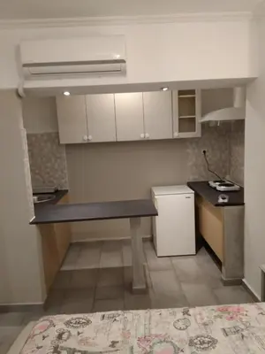a small kitchen with a table and a refrigerator at Yiannis Kalimarmaro Studio,Athens Center in Athens