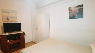 a bedroom with a bed and a tv and a cabinet at Yiannis Kalimarmaro Studio,Athens Center in Athens