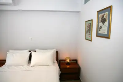 a bedroom with a bed and a night stand with a candle at Feels like home with luxury details in Athens
