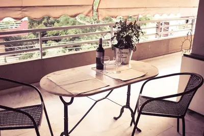 a table with a bottle of wine and two chairs at City Break Nearby Metro And Bus Express Airport in Athens
