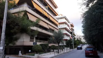 a building with cars parked in front of it on a street at City Break Nearby Metro And Bus Express Airport in Athens