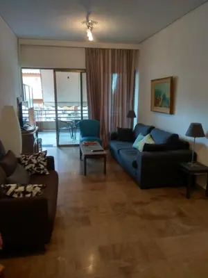 a living room with a blue couch and a table at City Break Nearby Metro And Bus Express Airport in Athens