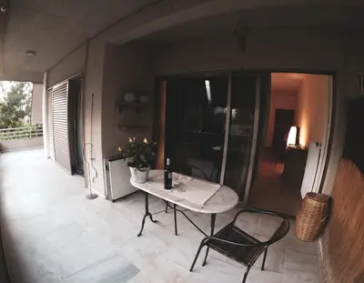a patio with a table and chairs on a balcony at City Break Nearby Metro And Bus Express Airport in Athens