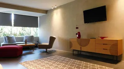 a living room with a couch and a tv on the wall at 101 Adrianou Apartments in Athens