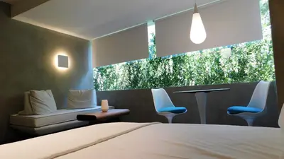a bedroom with a bed and two chairs and a window at 101 Adrianou Apartments in Athens