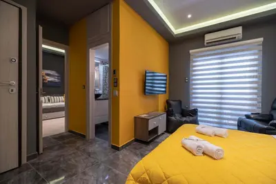 a bedroom with a yellow bed with two towels on it at Cool Style Private Apartments in Athens