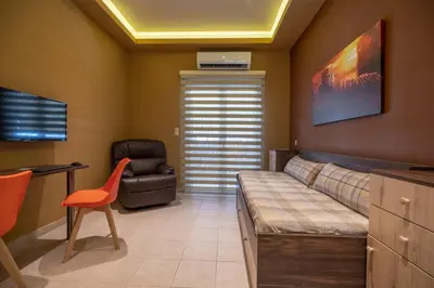 a room with a couch and a chair and a desk at Cool Style Private Apartments in Athens