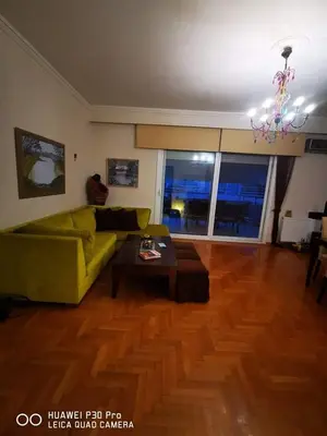 a living room with a green couch and a table at Annadel Flat in Athens