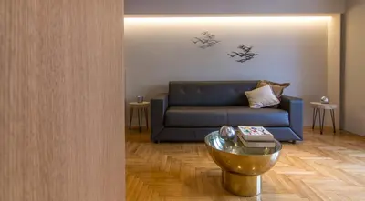 a living room with a blue couch and a table at ABA Junior Apartment Veikou street in Athens