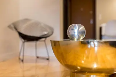 a glass bowl with a spoon on a table with a chair at ABA Junior Apartment Veikou street in Athens