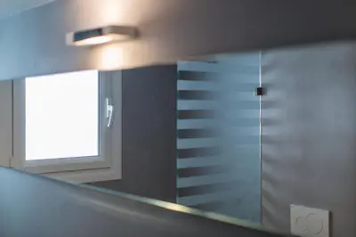 a mirror in a bathroom with a window at ABA Junior Apartment Veikou street in Athens