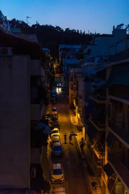 a city street at night with cars parked at ABA Junior Apartment Veikou street in Athens