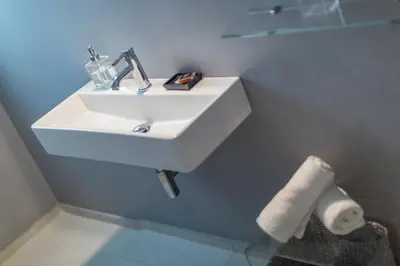 a bathroom with a white sink in a blue wall at ABA Junior Apartment Veikou street in Athens