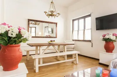 a living room with a table and flowers in vases at Vintage Charm by the Acropolis! in Athens