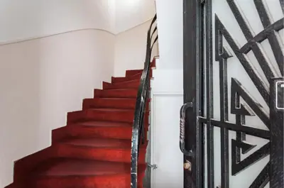 a staircase with red carpeting and a wrought iron gate at Vintage Charm by the Acropolis! in Athens