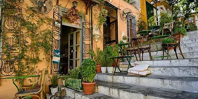 a building with potted plants on the side of it at Vintage Charm by the Acropolis! in Athens