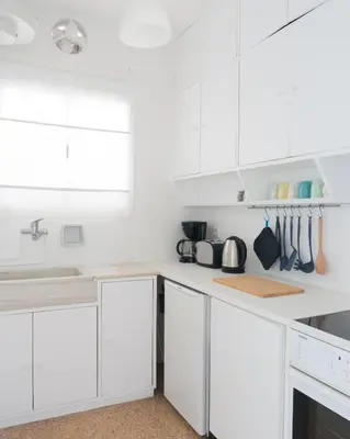 a white kitchen with white cabinets and a window at Ariadne's Penthouse in Central Athens in Athens