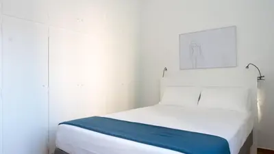 a bedroom with a white bed with a blue blanket at Ariadne's Penthouse in Central Athens in Athens