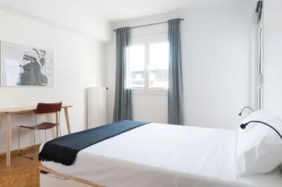 a bedroom with a bed and a desk and a window at Ariadne's Penthouse in Central Athens in Athens