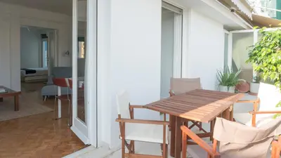 a balcony with a wooden table and chairs at Ariadne's Penthouse in Central Athens in Athens