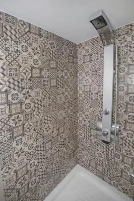 a bathroom with a shower with a tiled wall at Acropolis Gem by GHH in Athens
